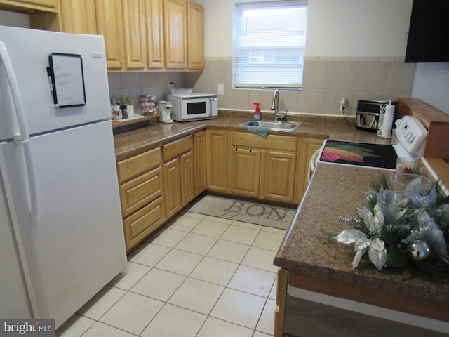 kitchen featuring white appliances, light tile patterned flooring, and sink