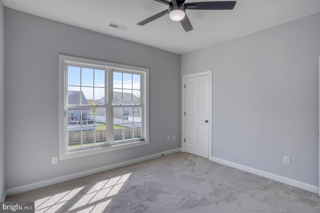 spare room with ceiling fan and light colored carpet