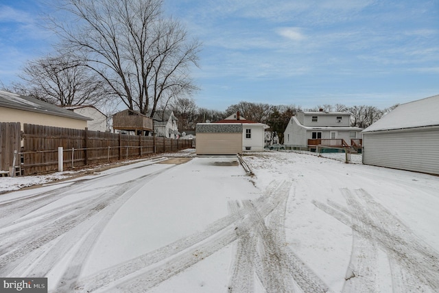 snowy yard with a storage shed