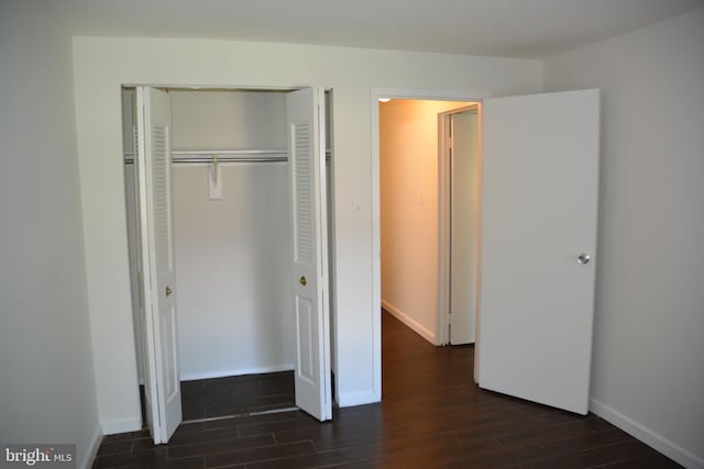 unfurnished bedroom featuring a closet and dark hardwood / wood-style flooring