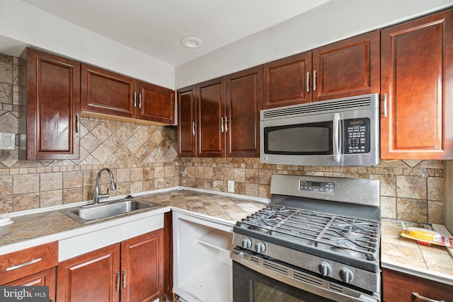 kitchen featuring appliances with stainless steel finishes, sink, and tasteful backsplash