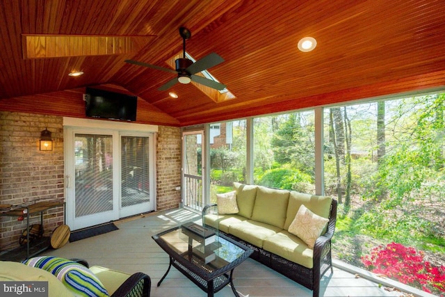 unfurnished sunroom featuring ceiling fan, vaulted ceiling with skylight, and wood ceiling