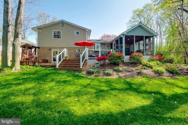 back of house featuring a wooden deck, a sunroom, and a yard