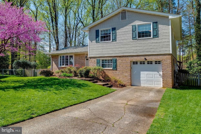 tri-level home with a garage and a front lawn