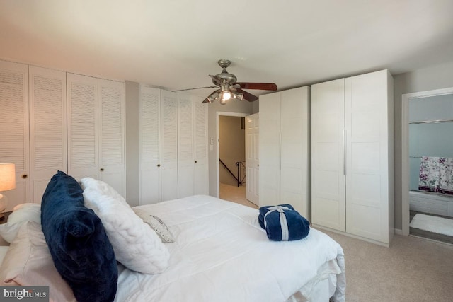 carpeted bedroom featuring ceiling fan and two closets