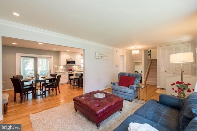 living room with crown molding and light hardwood / wood-style flooring