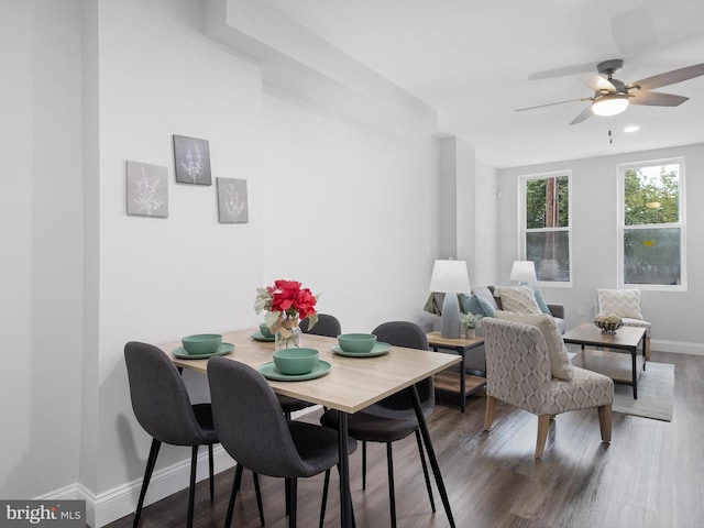 dining space with ceiling fan and dark wood-type flooring