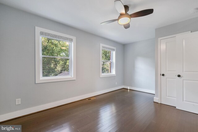 unfurnished bedroom featuring ceiling fan and dark hardwood / wood-style flooring