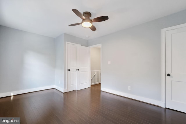 empty room with dark hardwood / wood-style floors and ceiling fan