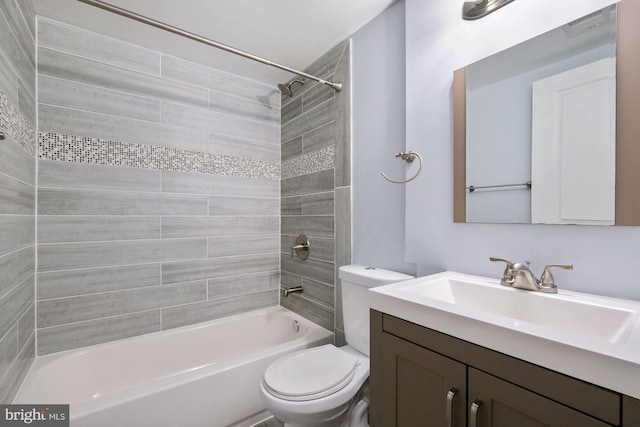 full bathroom with vanity, tiled shower / bath combo, and toilet