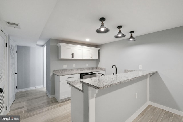 kitchen featuring light hardwood / wood-style flooring, kitchen peninsula, and white cabinetry