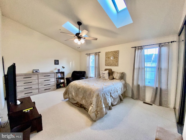 bedroom with ceiling fan, carpet floors, and lofted ceiling with skylight