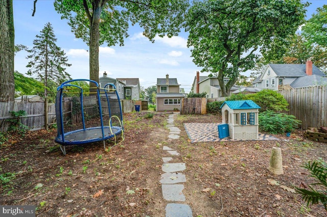 view of yard featuring a trampoline and a storage shed