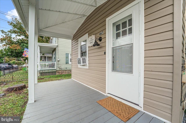 wooden terrace with cooling unit and covered porch