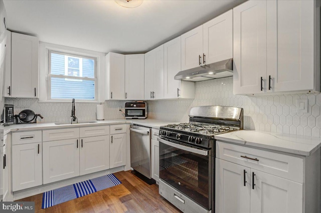 kitchen with white cabinets, wood-type flooring, appliances with stainless steel finishes, and sink