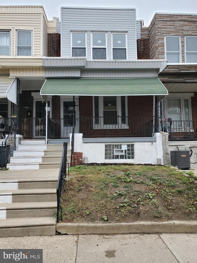 view of front of house with covered porch and central AC unit