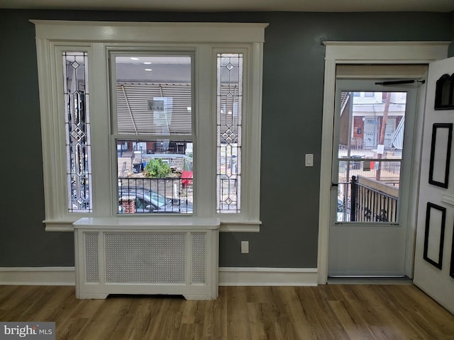 foyer with radiator and hardwood / wood-style floors