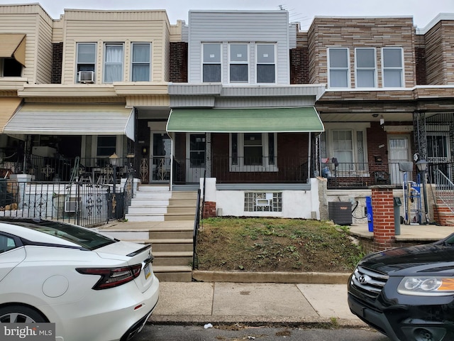 townhome / multi-family property featuring cooling unit, central AC, and a porch