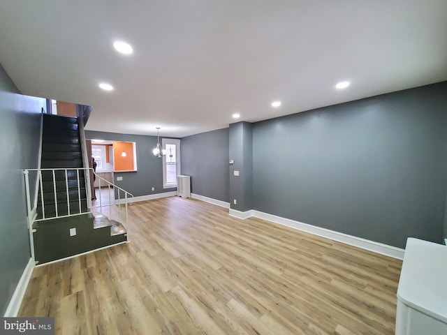 unfurnished living room with light hardwood / wood-style flooring and a chandelier