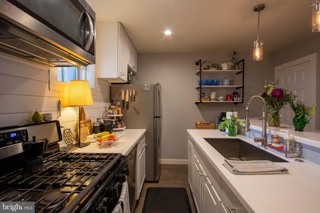 kitchen featuring white cabinetry, tasteful backsplash, stainless steel appliances, decorative light fixtures, and sink