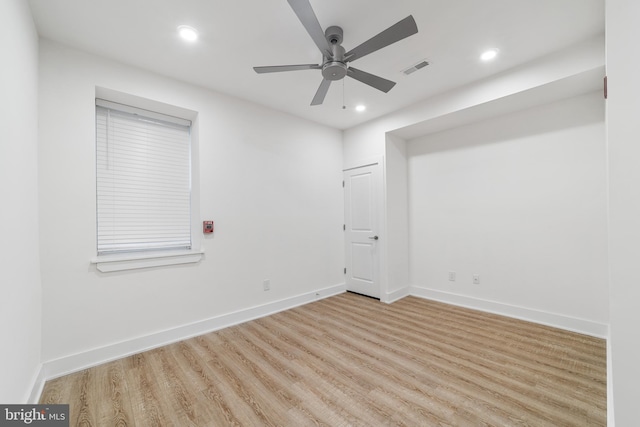 empty room with ceiling fan and light hardwood / wood-style flooring