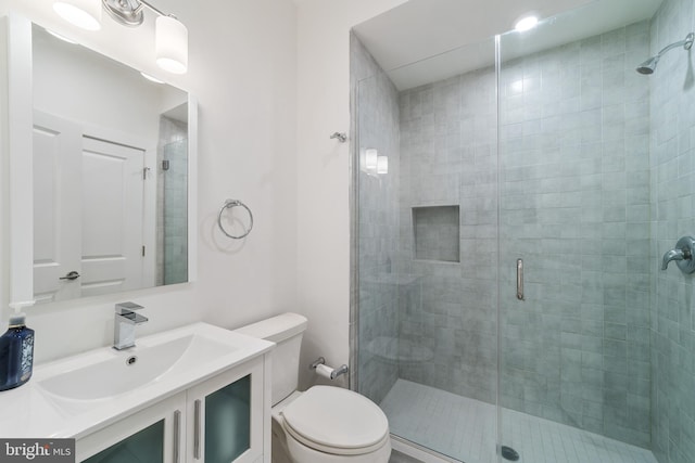 bathroom featuring an enclosed shower, vanity, and toilet