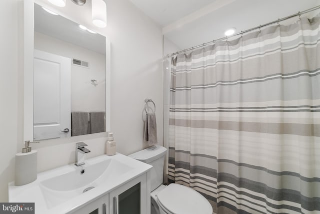 bathroom with curtained shower, vanity, and toilet