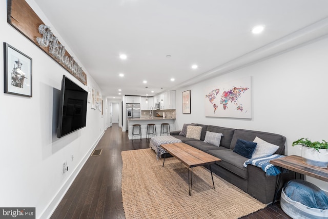 living room featuring wood-type flooring and sink