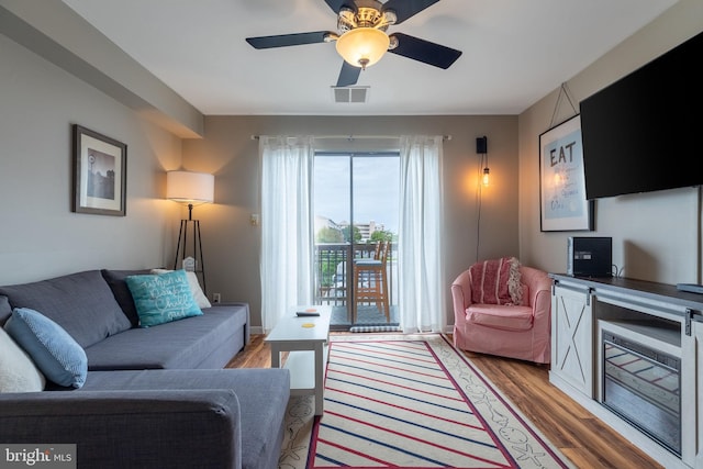 living room featuring light hardwood / wood-style floors and ceiling fan