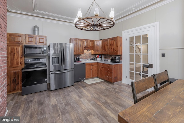 kitchen featuring dark hardwood / wood-style floors, an inviting chandelier, black appliances, backsplash, and crown molding