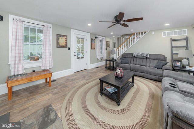 living room with ceiling fan and light hardwood / wood-style flooring