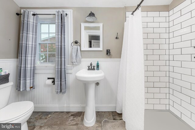 bathroom featuring curtained shower and toilet