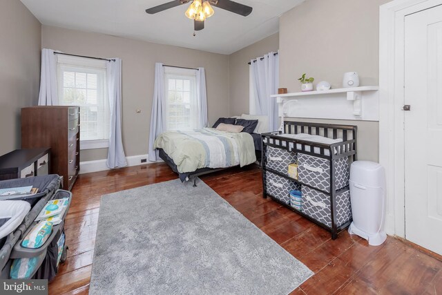 bedroom with dark hardwood / wood-style floors and ceiling fan