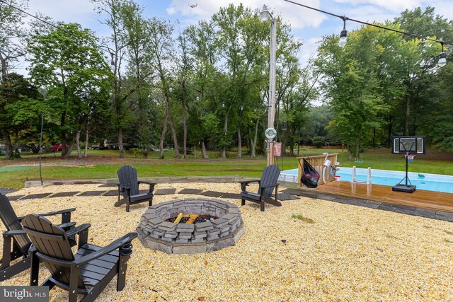 view of yard with a deck and an outdoor fire pit