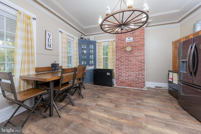 dining space with ornamental molding, dark hardwood / wood-style flooring, a chandelier, and plenty of natural light