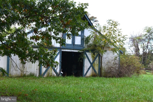 view of side of home with a storage shed and a yard