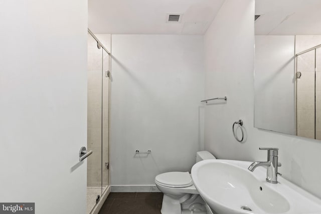 bathroom with toilet, a shower with door, sink, and tile patterned flooring