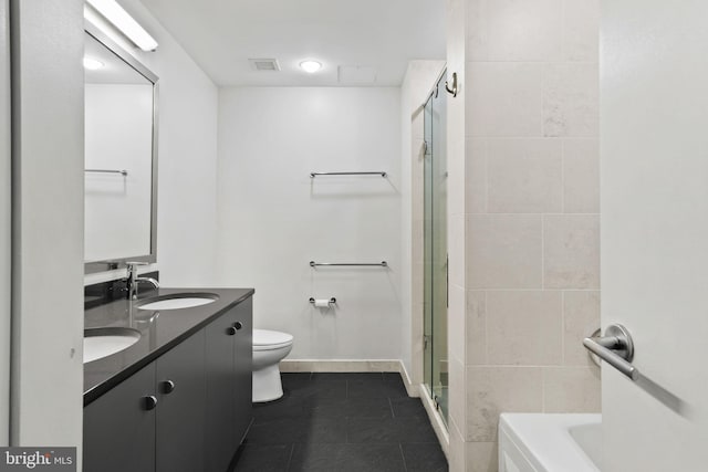 bathroom with vanity, toilet, a shower with door, and tile patterned floors