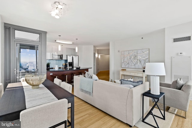 living room with a notable chandelier and light hardwood / wood-style floors