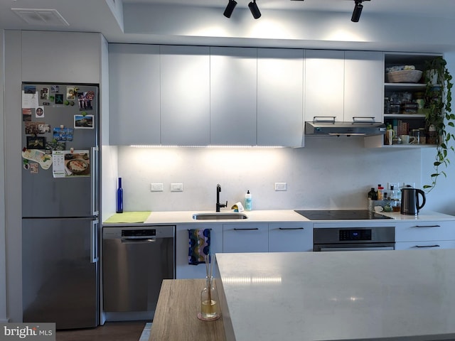 kitchen with appliances with stainless steel finishes, white cabinetry, and sink