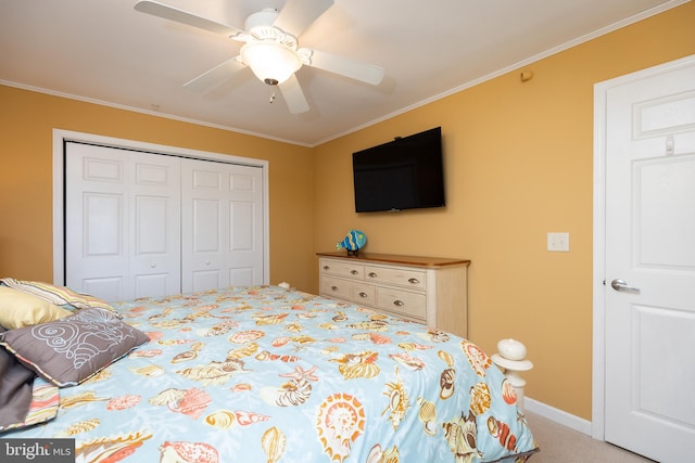 carpeted bedroom featuring ornamental molding, ceiling fan, and a closet