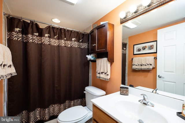 bathroom with walk in shower, vanity, and toilet