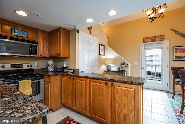 kitchen featuring stainless steel appliances, a chandelier, light tile patterned floors, and kitchen peninsula