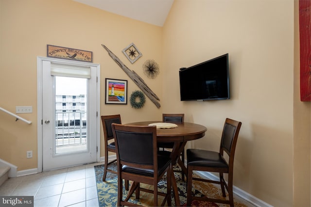 tiled dining room featuring lofted ceiling