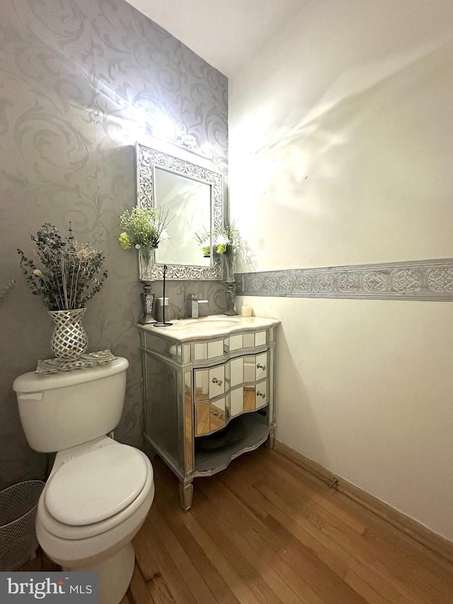 bathroom with toilet, vanity, and hardwood / wood-style flooring