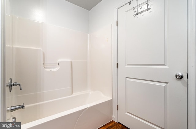 bathroom featuring wood-type flooring and shower / washtub combination