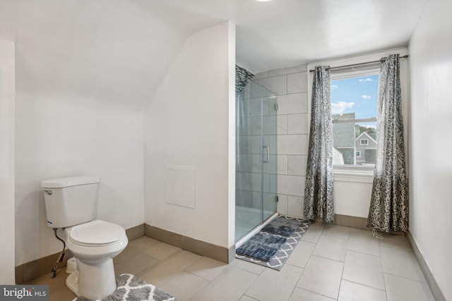 bathroom featuring tile patterned flooring, toilet, and a shower with shower door