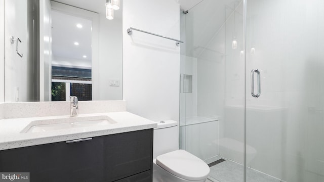 bathroom featuring vanity, a shower with shower door, and toilet