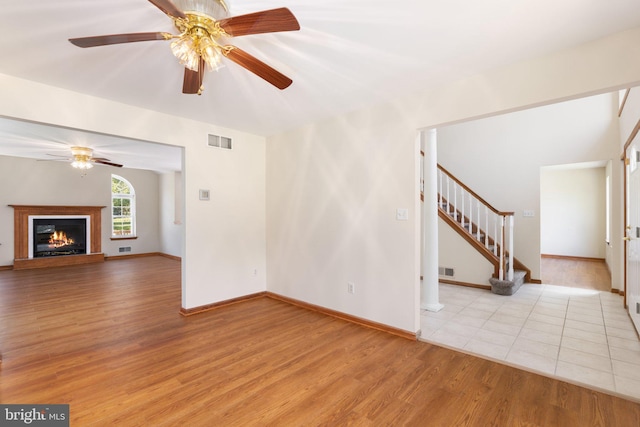 unfurnished living room with light wood-type flooring and ceiling fan