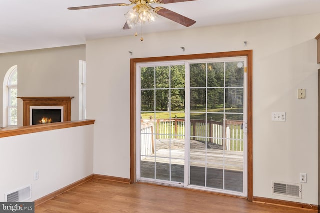 interior space featuring light wood-type flooring, ceiling fan, and plenty of natural light